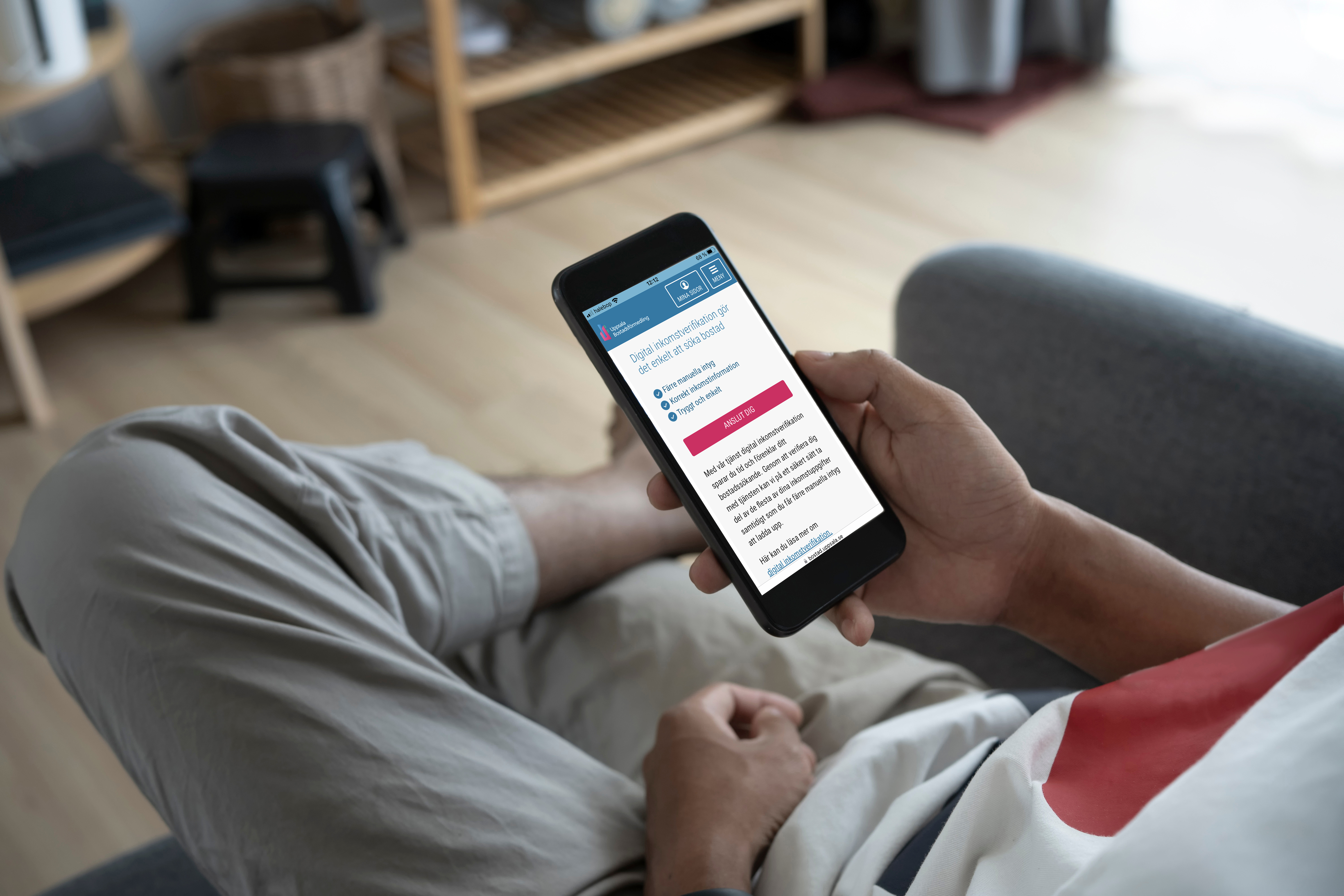 En person läser digitalt avtal på mobil i soffa.