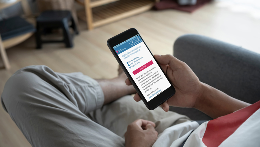 En person läser digitalt avtal på mobil i soffa.